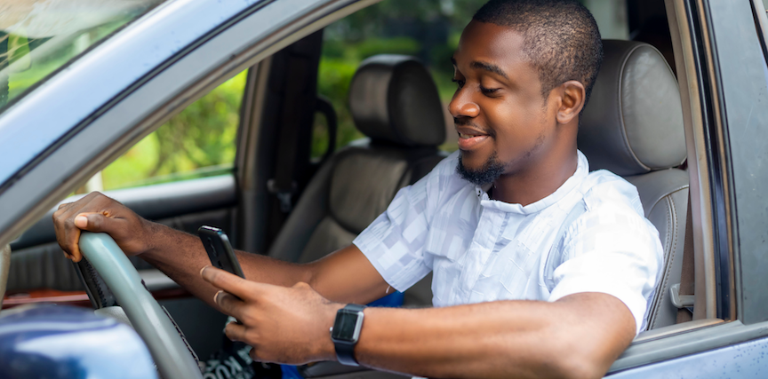 Man looking at mobile device in car
